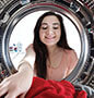 Woman getting clothes from dryer