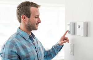 Man adjusting thermostat