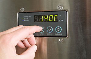 ai_pl_waterheater_replace1 Hand adjusting thermostat on water heater