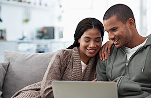 Couple on sofa looking at laptop